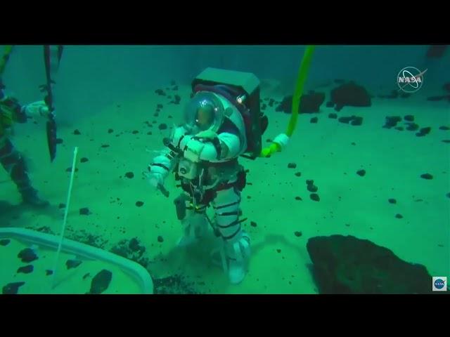 NASA astronauts test new spacesuit in pool, plant flag