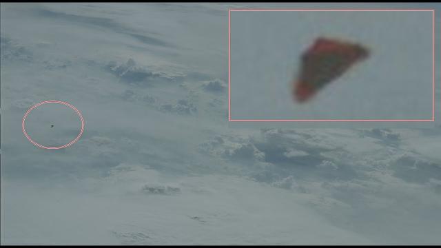 Reddish triangular UFO Seen Outside Of Shuttle Discovery