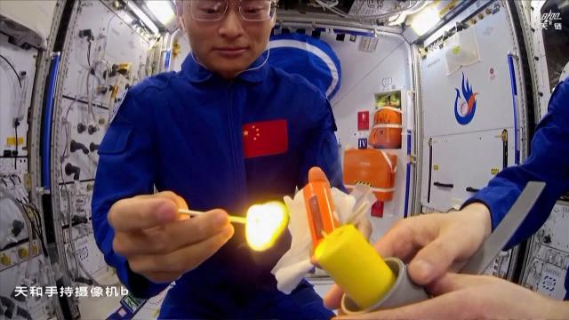 Chinese astronauts light candle with match on Tiangong space station to show flame behavior