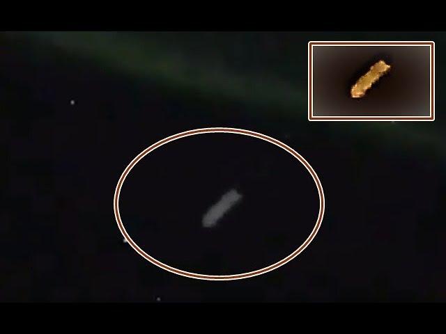 Cigar-shaped UFO flying through space during display of the Northern Lights