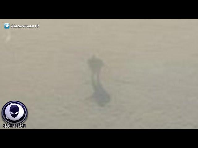 EERIE Pic Of Giant Robot Walking On Clouds Outside Plane