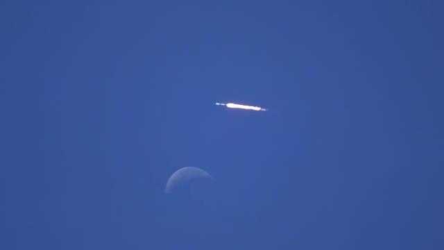 SpaceX Falcon 9 rocket soars past daytime moon during launch